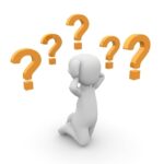 Figure kneels holding head as question marks float above him