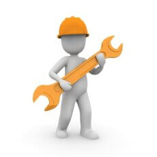 figure in orange hard hat holding an orange wrench